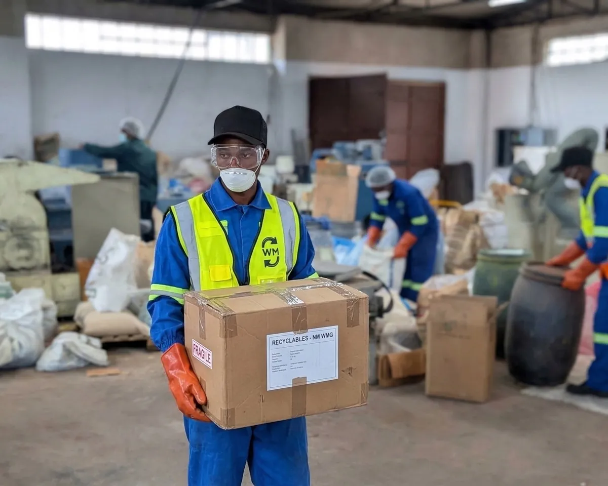 WasteMate worker in PPE handling recyclables at sorting facility